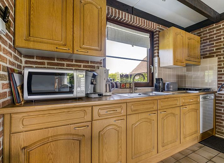 Helles Wohnzimmer des Ferienhauses Haus Anni in Hansweert, Zuid-Beveland, mit offener Kueche und Gartenblick.