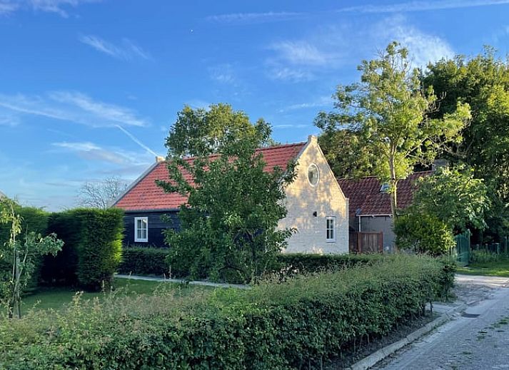 Gezellige eetruimte in Vakantiehuis in Lewedorp, Zuid-Beveland met rustieke houten tafel en decoratieve elementen.