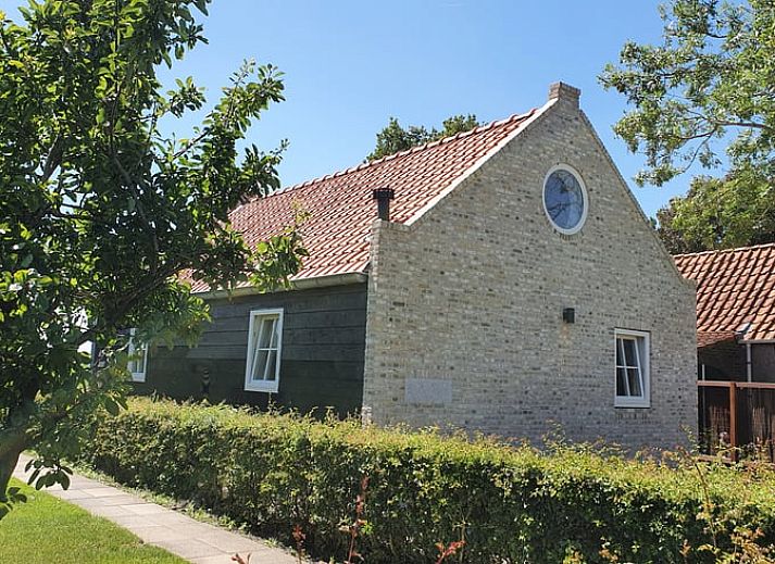 Gezellige eetruimte in Vakantiehuis in Lewedorp, Zuid-Beveland met rustieke houten tafel en decoratieve elementen.