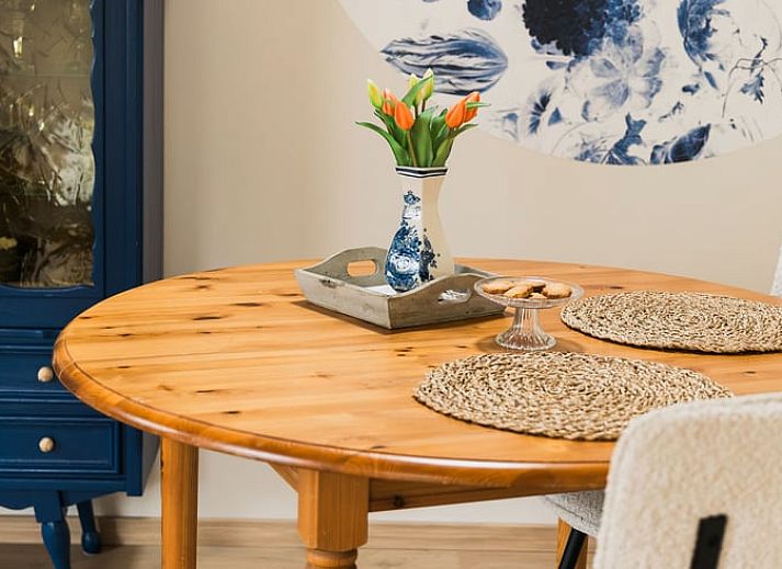 Gezellige eetruimte in Vakantiehuis in Lewedorp, Zuid-Beveland met rustieke houten tafel en decoratieve elementen.