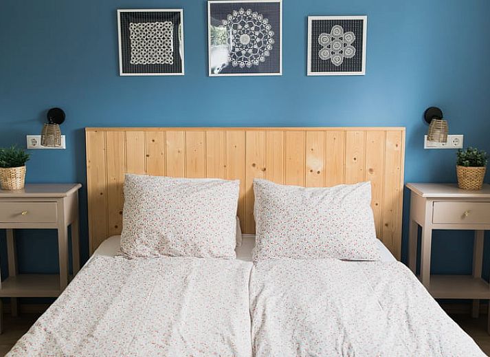 Eettafel met bloemenvaas in Vakantiehuis in Lewedorp, Zuid-Beveland, ideaal voor gezellige maaltijden.