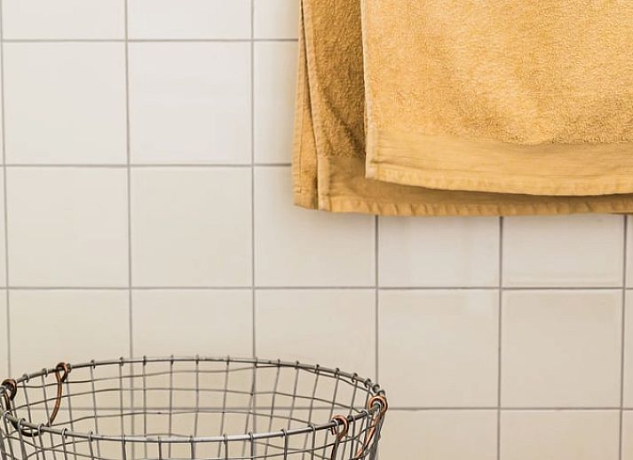 Eettafel met bloemenvaas in Vakantiehuis in Lewedorp, Zuid-Beveland, ideaal voor gezellige maaltijden.