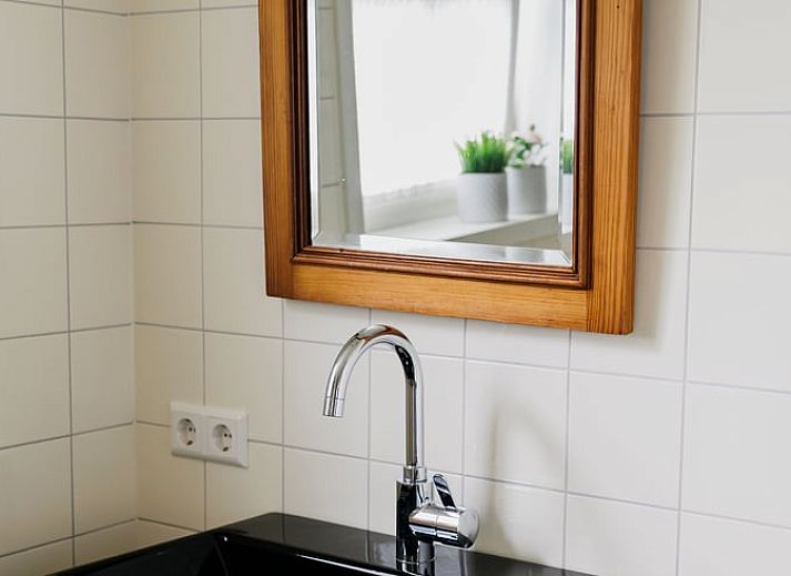 Eettafel met bloemenvaas in Vakantiehuis in Lewedorp, Zuid-Beveland, ideaal voor gezellige maaltijden.