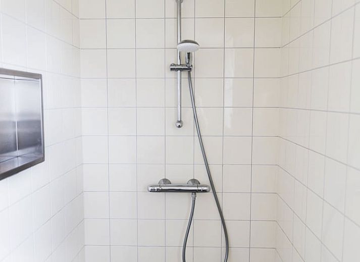 Eettafel met bloemenvaas in Vakantiehuis in Lewedorp, Zuid-Beveland, ideaal voor gezellige maaltijden.