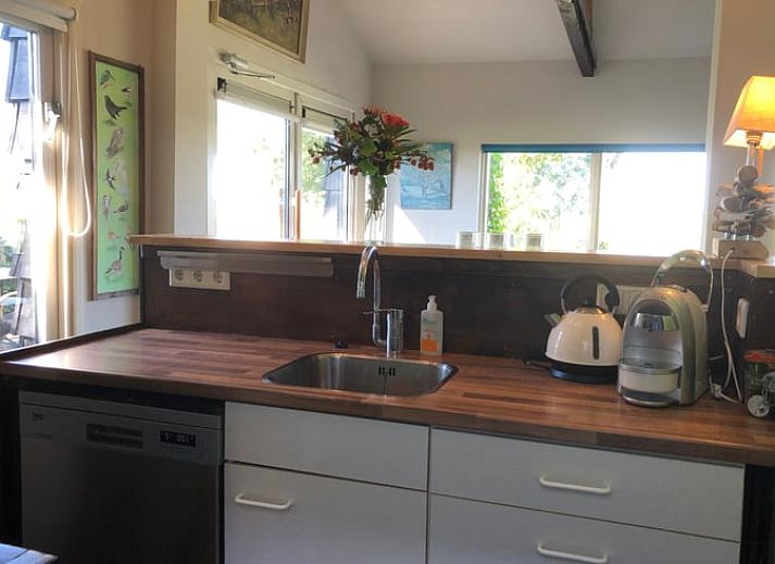 Gemuetlicher Innenbereich des Ferienhauses Cottage in Brandwijk, mit bequemem Sofa und stimmungsvoller Beleuchtung.