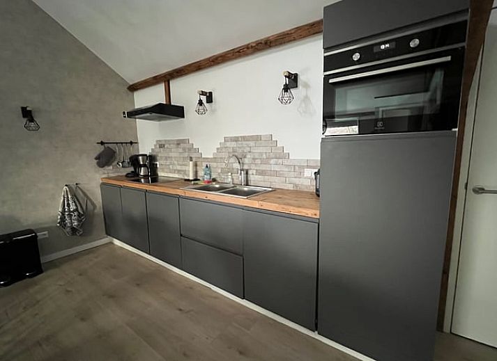 Cozy living room in vacation home Streefkerk, with comfortable sofa and natural light.