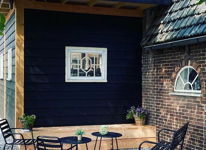 Cozy living room in vacation home Streefkerk, with comfortable sofa and natural light.