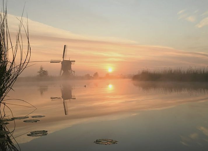 Cozy living room in vacation home Streefkerk, with comfortable sofa and natural light.