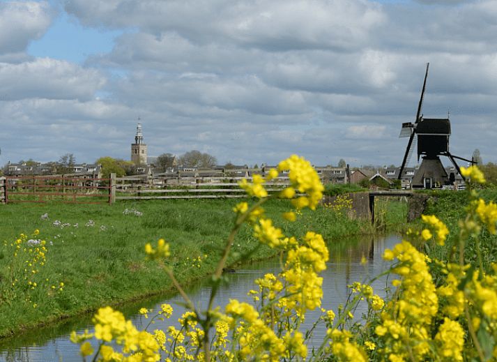 Open living space in vacation home Streefkerk, with dining area and stairs to upper floor.