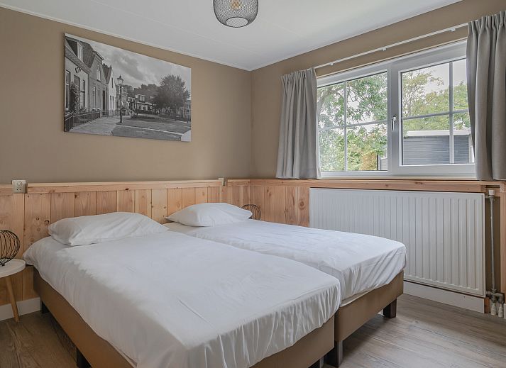 Bungalow Renesse in Ouddorp biedt een gezellig terras met comfortabele stoelen, ideaal voor ontspanning in de natuur van Goeree-Overflakkee.