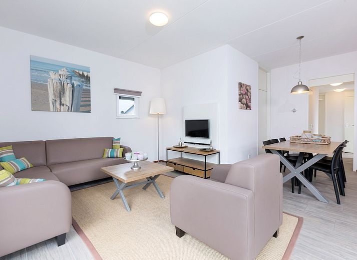 Gemuetliches Wohnzimmer von Bungalow 6C in Ouddorp, Goeree-Overflakkee, Suedholland, mit bequemer Sitzecke und modernem Essbereich.