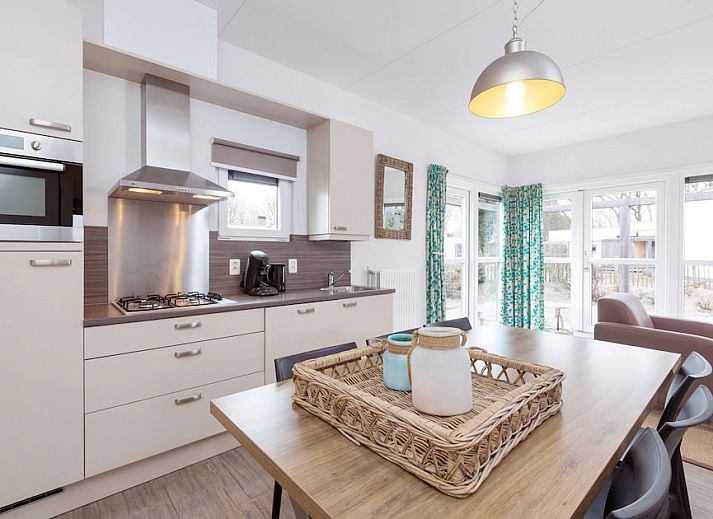 Gemuetliches Wohnzimmer von Bungalow 6C in Ouddorp, Goeree-Overflakkee, Suedholland, mit bequemer Sitzecke und modernem Essbereich.