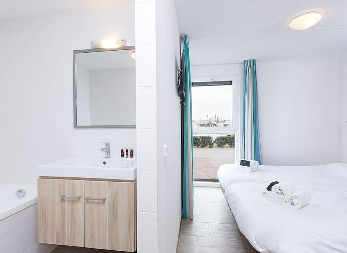 Gemuetliches Wohnzimmer von Bungalow 6C in Ouddorp, Goeree-Overflakkee, Suedholland, mit bequemer Sitzecke und modernem Essbereich.