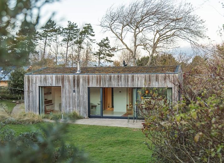 Ferienhaus in Ouddorp, umgeben von Natur auf Goeree-Overflakkee, Suedholland, mit moderner Holzfassade und grossem Garten.