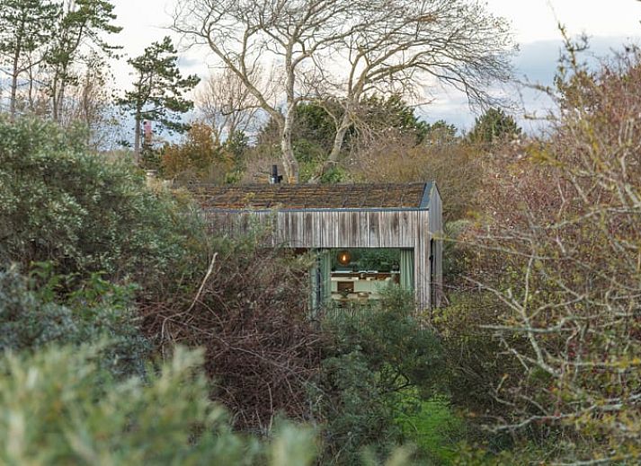 Gemuetliches Wohnzimmer mit Holzofen im Ferienhaus in Ouddorp, Suedholland, ideal zum Entspannen und Geniessen der Aussicht auf die Natur.