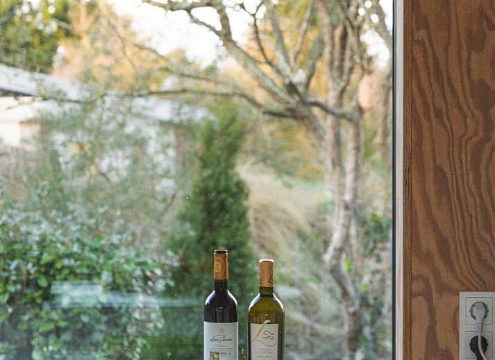 Moderne Kueche im Ferienhaus in Ouddorp, Goeree-Overflakkee, mit Blick auf die Natur durch ein grosses Fenster. Gemuetlicher Aufenthalt in Suedholland.