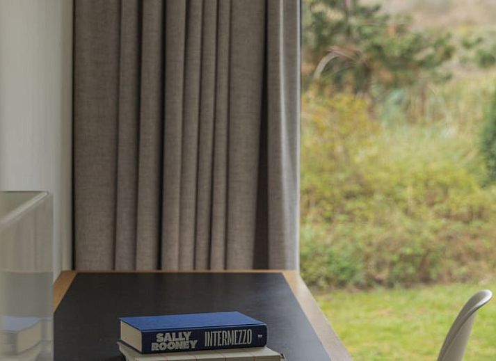 Moderne Kueche im Ferienhaus in Ouddorp, Goeree-Overflakkee, mit Blick auf die Natur durch ein grosses Fenster. Gemuetlicher Aufenthalt in Suedholland.