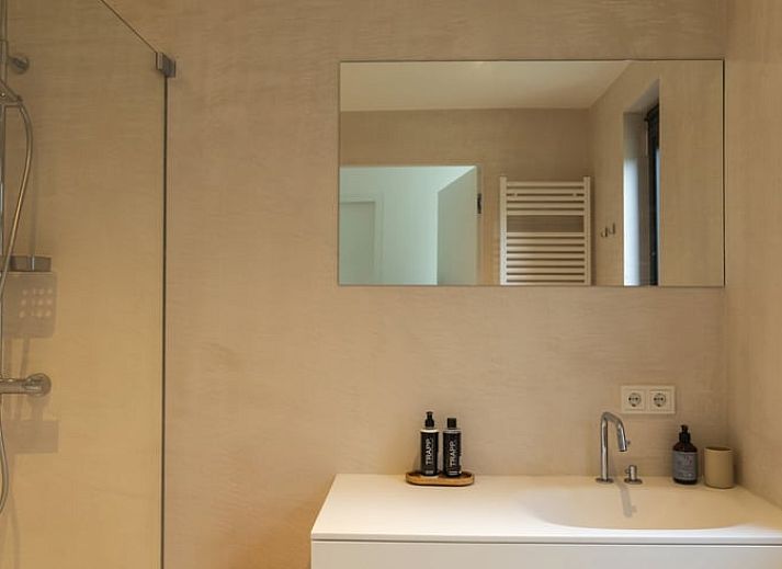 Gemuetlicher Essbereich im Ferienhaus in Ouddorp mit Blick auf den gruenen Garten, gelegen in Ouddorp, Goeree-Overflakkee, Suedholland.