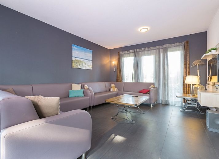 Gezellige woonkamer met open haard in Familievilla 14, een vakantiehuis in Ouddorp, Goeree-Overflakkee, Zuid-Holland.