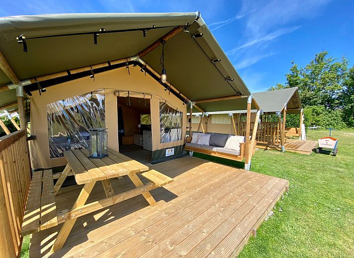 Gemuetlicher Innenbereich des Safaritent Zeeduin in Ouddorp, Goeree-Overflakkee, mit Kueche und Sitzecke in einer Glamping-Lodge.