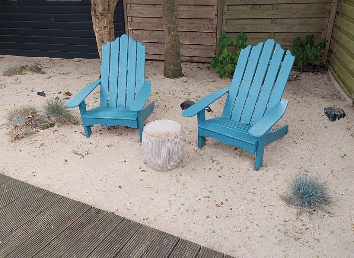 Chalet Sunrise with private beach garden in Ouddorp, Zeeland, offers a sunny terrace with comfortable deck chairs and green views.