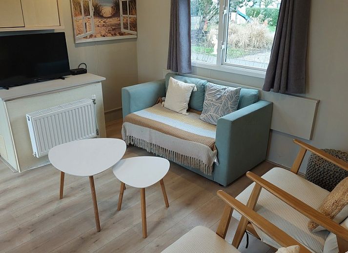 Chalet Sunrise with private beach garden in Ouddorp, Zeeland, offers a sunny terrace with comfortable deck chairs and green views.