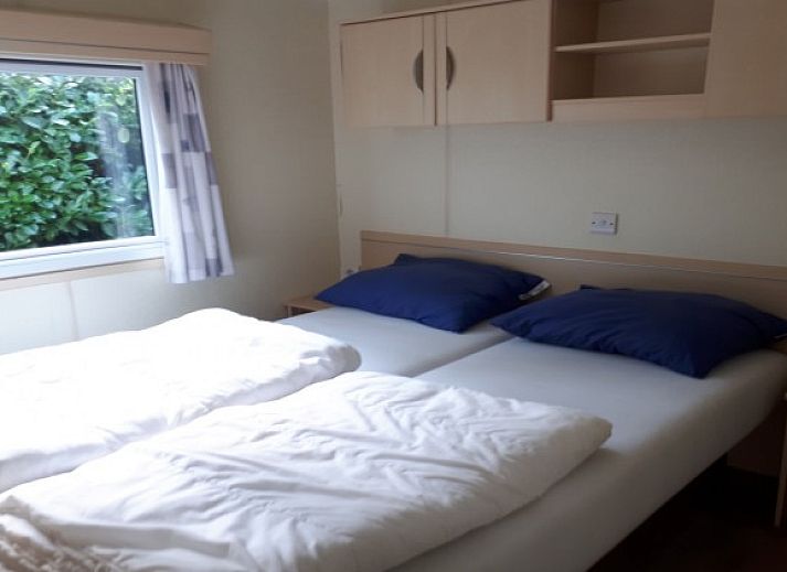 Enjoy the green surroundings and wooden veranda at Chalet Sunrise with private beach garden in Ouddorp, Zeeland.