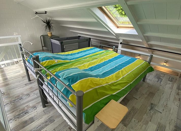 Blick von der Terrasse des Ferienhauses VZ991 in Ouddorp, mit gruenem Zaun.