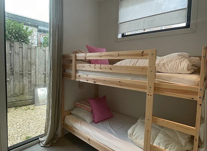 Veranda of House in Ouddorp, vacation accommodation in Ouddorp, South Holland with seating and green surroundings.