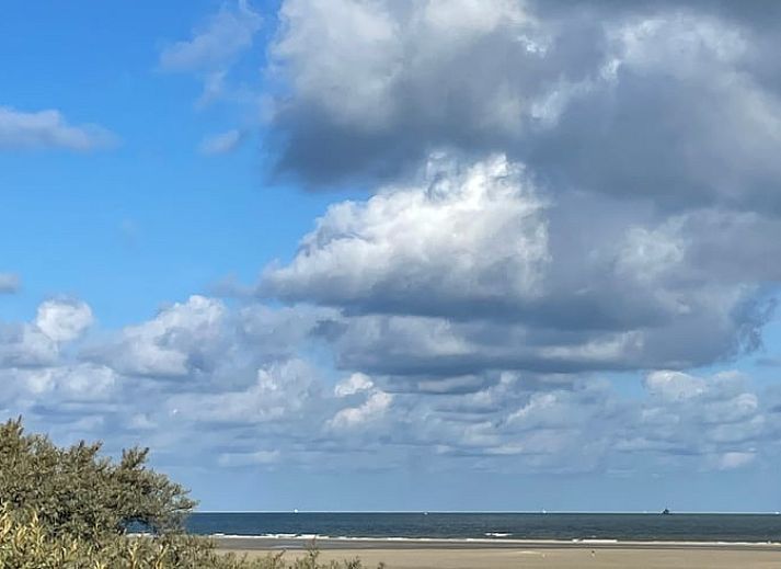 Veranda of House in Ouddorp, vacation accommodation in Ouddorp, South Holland with seating and green surroundings.