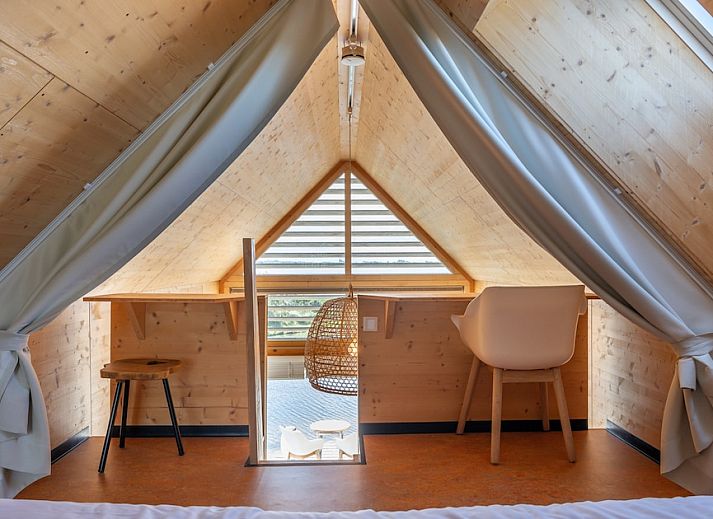 Gezellige binnenruimte van ECO Cottage in Ouddorp, Zuid-Holland, met houten interieur en comfortabele zitbank, ideaal voor ontspanning.