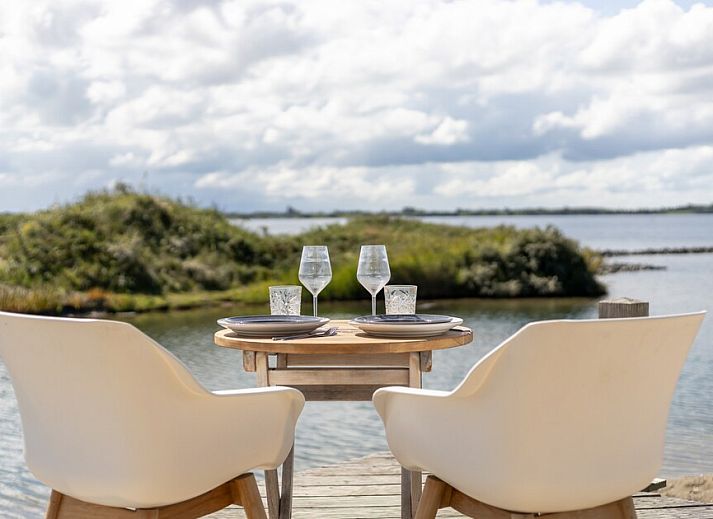 Geniet van het serene uitzicht vanaf de veranda van ECO Cottage, een vakantiehuis in Ouddorp, Goeree-Overflakkee, Zuid-Holland.