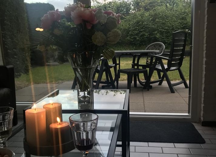 Eetkamer van Vakantiehuis Ouddorp met stijlvolle houten tafel en kunst aan de muur in Ouddorp.