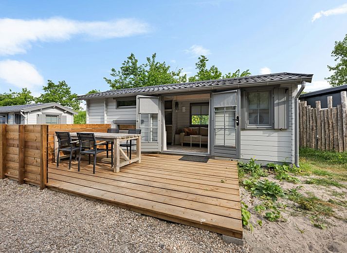 Innenbereich des Kampeerchalet de Zeekoet in Ouddorp mit gemuetlicher Sitzecke und Blick auf die Natur von Goeree-Overflakkee.