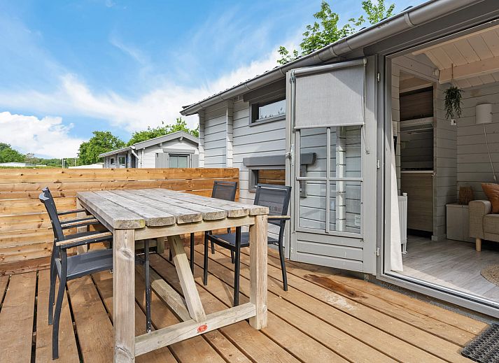 Innenbereich des Kampeerchalet de Zeekoet in Ouddorp mit gemuetlicher Sitzecke und Blick auf die Natur von Goeree-Overflakkee.