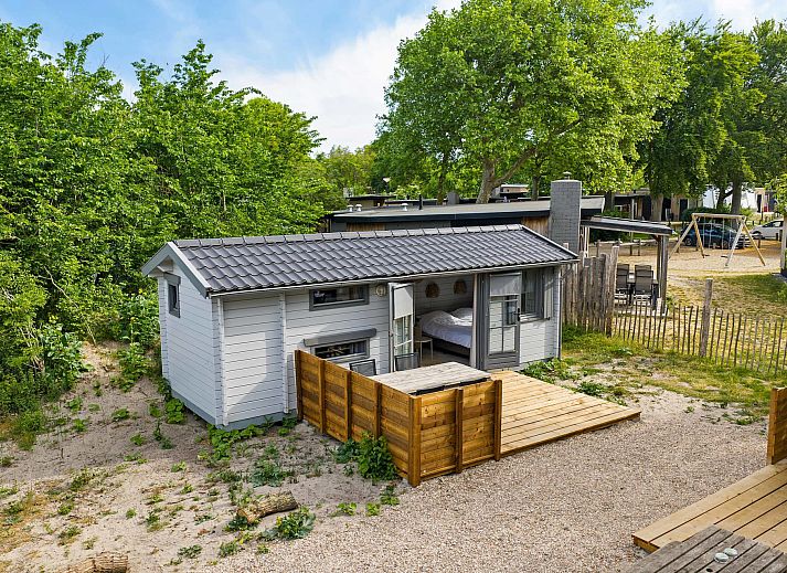Innenbereich des Kampeerchalet de Zeekoet in Ouddorp mit gemuetlicher Sitzecke und Blick auf die Natur von Goeree-Overflakkee.