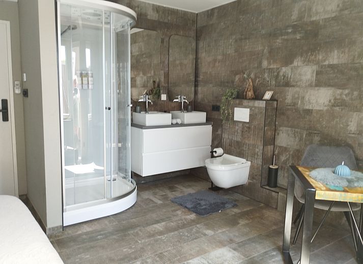 Slaapkamer in ZH415 vakantiehuis, Ouddorp, Zuid-Holland met modern interieur en comfortabele zitplek.