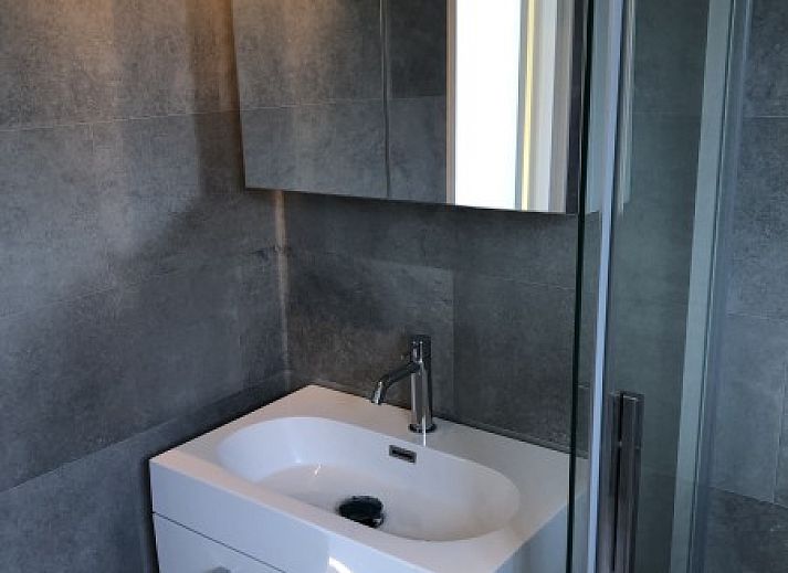 Detail der Holzveranda des Chalets Thuiz in Ouddorp, Suedholland, mit einer warmen, natuerlichen Ausstrahlung.