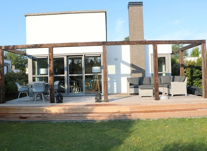 Terras van DichterbijZee in Ouddorp met comfortabele zitplaatsen en uitzicht op de groene omgeving van Goeree-Overflakkee.