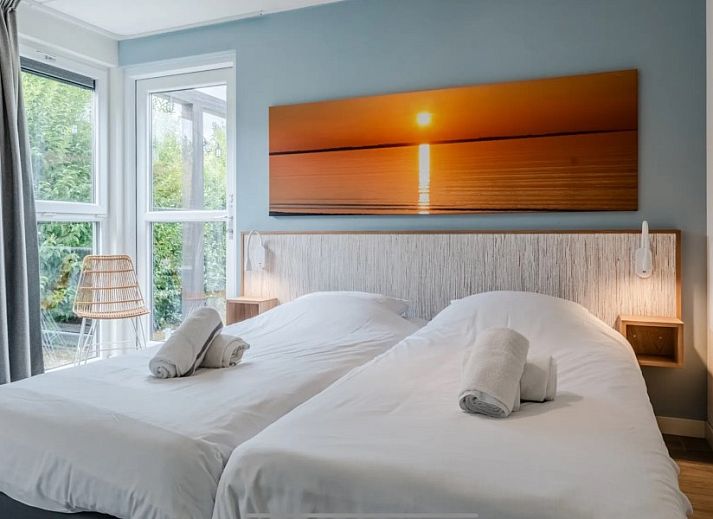 Uitzicht vanuit de woonkamer van DichterbijZee in Ouddorp op de groene tuin en het terras, ideaal voor natuurliefhebbers.