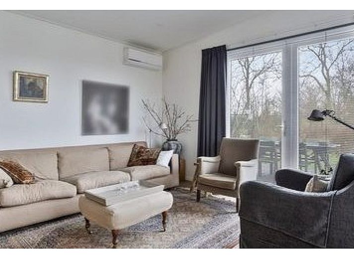 Gemtliches Wohnzimmer in Cabin, Grote Stern 16, Ouddorp mit gerumiger Sitzecke und Blick auf Goeree-Overflakkee Natur.