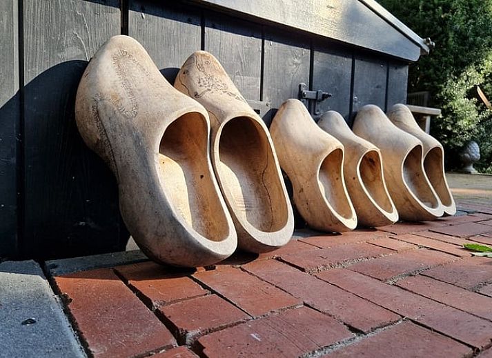 Dining area with wooden table in Holiday home in Ouddorp, South Holland.