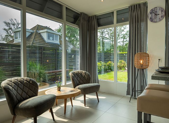 Gezellig terras met schommelstoel bij Vakantiewoning De Toekomst 107 'Siesta' in Ouddorp, perfect voor een ontspannen middag.