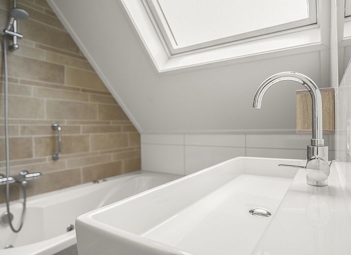 Moderne Kueche in der 6-Personen-Villa Zeeduin des Strand Resort Ouddorp Duin in Ouddorp, Suedholland, mit Kochinsel und Zugang zur Terrasse.