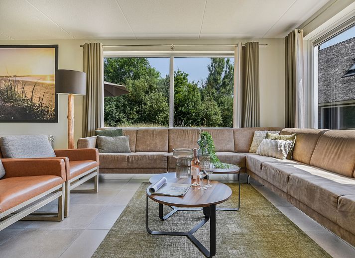 Moderne woonkamer met uitzicht op de natuur bij Strand Resort Ouddorp Duin.
