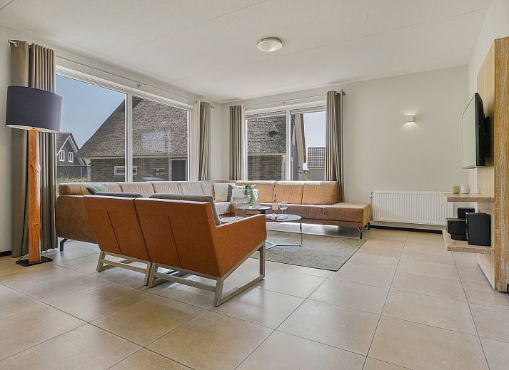 Moderne woonkamer met uitzicht op de natuur bij Strand Resort Ouddorp Duin.