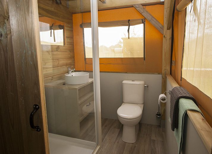 Veranda des Safarizeltes Duinroos in Ouddorp, einer Glamping Lodge in Goeree-Overflakkee, Suedholland, umgeben von gruener Natur.