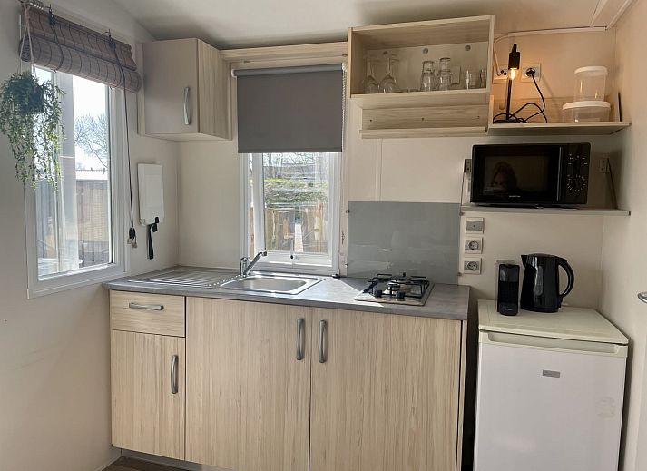 Gemuetlicher Innenbereich des Mobilheims der Kormoran in Ouddorp, Goeree-Overflakkee mit Blick auf die Terrasse und die gruene Umgebung.