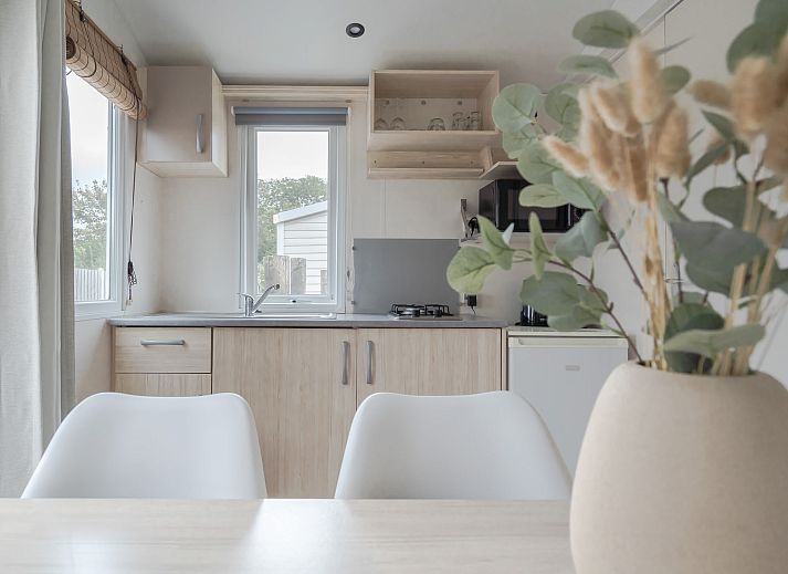 Gemuetlicher Innenbereich des Mobilheims der Kormoran in Ouddorp, Goeree-Overflakkee mit Blick auf die Terrasse und die gruene Umgebung.