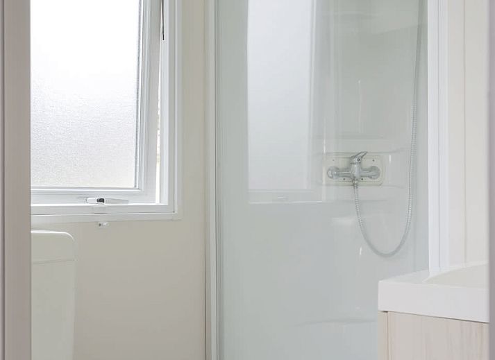 Gemuetlicher Innenbereich des Mobilheims der Kormoran in Ouddorp, Goeree-Overflakkee mit Blick auf die Terrasse und die gruene Umgebung.